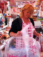 an operator spinning candy floss on the fairground