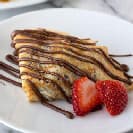 French Crepe Drizzled With Chocolate and Strawberries